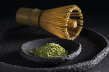 Dried tea leaves in heap on plate with chasen for tea ceremony - ADSF23895