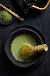 From above of traditional Japanese matcha with tea whisk in stone bowl for traditional oriental ceremony - ADSF23899