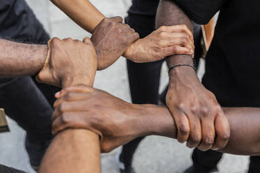 Oben: Anonyme afroamerikanische Partner halten sich an den Händen und demonstrieren damit ein Symbol der Einheit in der Stadt - ADSF23910