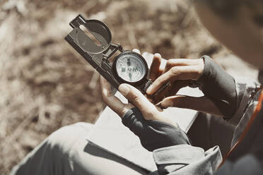 Frau benutzt Kompass an einem sonnigen Tag - AZF00317