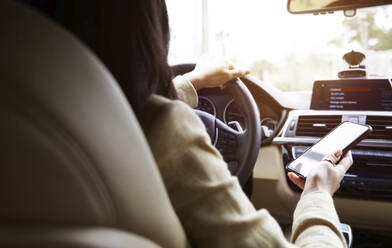 Frau benutzt Smartphone beim Autofahren - AZF00324