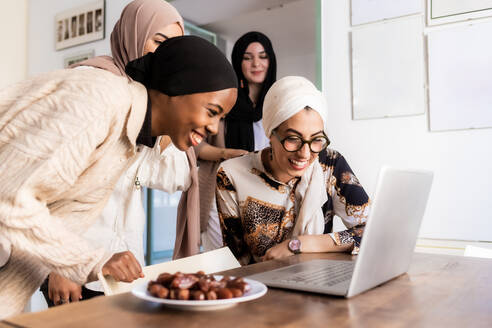 Young muslim women on video call, with plate of dates - ISF24438