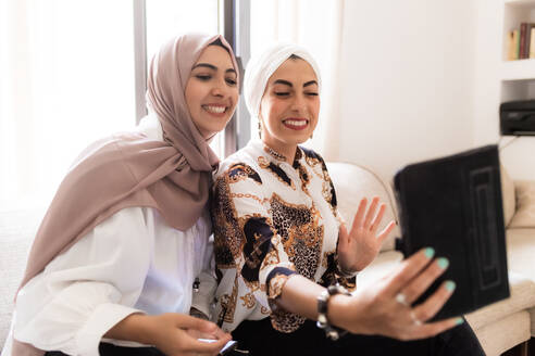 Two young women using tablet for video call - ISF24448