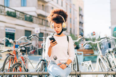 Young woman outdoors, looking at phone - ISF24465