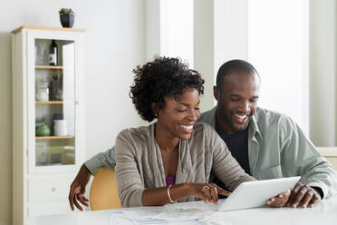 Mid adult couple using digital tablet - ISF24495