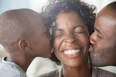 Boy and man kissing woman on cheeks - ISF24521