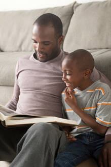 Vater und Sohn lesen ein Buch - ISF24523