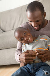 Portrait of son sitting on father's lap - ISF24564