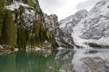 Malerische Kulisse des Pragser Wildsees, umgeben von immergrünen Wäldern und schneebedeckten Bergen - ADSF23947