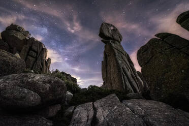 Hill with big ricks among green plants with colorful night sky with stars and milky way on background - ADSF24009