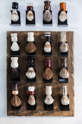 Collection of assorted brushes for shaving routine in barbershop hanging on wall for beauty treatments - ADSF24054