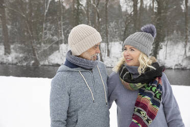 Senior couple in warm clothing looking at each other - FVDF00139