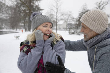 Senior man looking at woman at park during winter - FVDF00153