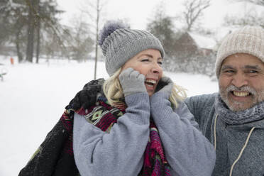 Cheerful woman and man in warm clothing at park during winter - FVDF00155