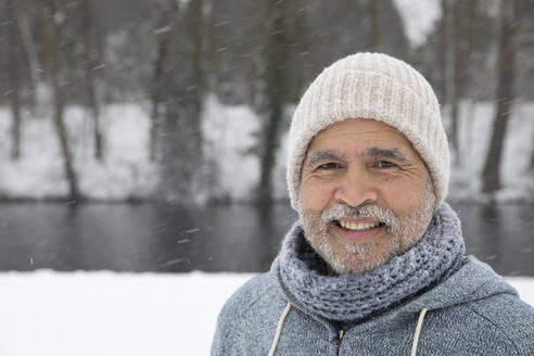 Älterer Mann mit Strickmütze, der im Winter lächelt - FVDF00156