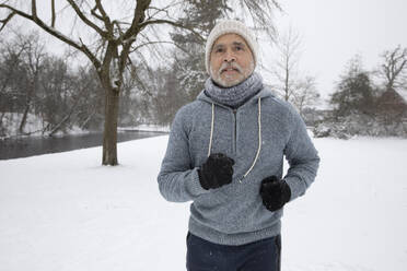 Älterer Mann in warmer Kleidung beim Laufen im Park - FVDF00158
