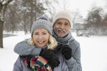 Älterer Mann mit Arm um eine Frau im Park im Winter - FVDF00163