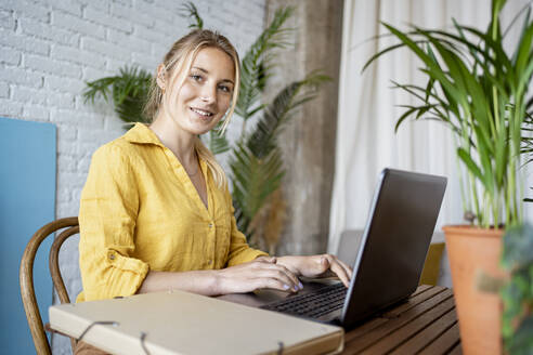 Female entrepreneur with laptop at home office - RCPF01025