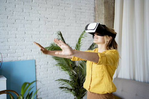 Junge Frau mit Virtual-Reality-Simulator zu Hause - RCPF01051