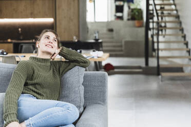 Woman day dreaming while listening music at home - MCVF00790