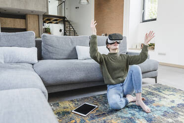 Woman using Virtual reality headset in living room at home - MCVF00800