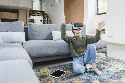 Frau mit Virtual-Reality-Headset im heimischen Wohnzimmer - MCVF00800