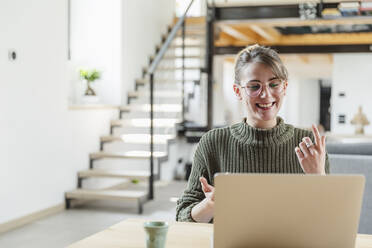 Businesswoman gesturing during video call on laptop at home - MCVF00818