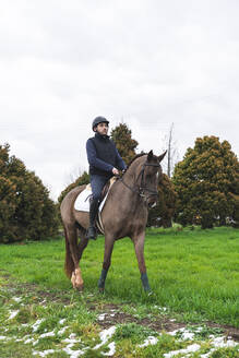 Mann reitet Pferd auf Gras - JAQF00607