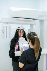 Female dentist taking dental x-ray of patient in clinic - DLTSF01866