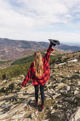 Frau mit erhobenem Arm und Hut auf einem Berg - RSGF00664