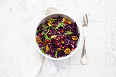 Schüssel mit veganem Salat mit Rotkohl, Granatapfelkernen, getrockneten Feigen, Walnüssen und Basilikum - LVF09157
