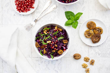 Schüssel mit veganem Salat mit Rotkohl, Granatapfelkernen, getrockneten Feigen, Walnüssen und Basilikum - LVF09159