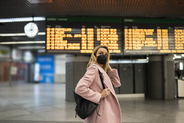 Mittlere erwachsene Frau mit Gesichtsschutzmaske auf einem Flughafen - JCCMF02208