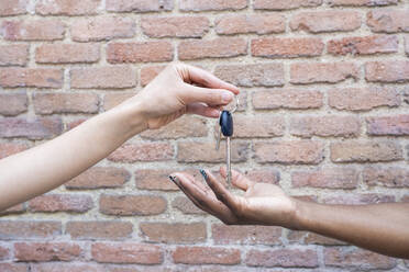Women handing keys to female friend - JCCMF02274