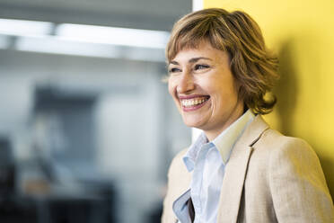 Mature female entrepreneur smiling while looking away - JOSEF04289
