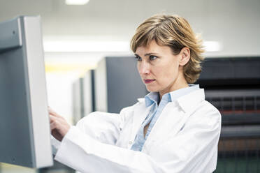 Female technician using printing machine in laboratory - JOSEF04333