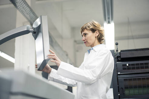 Reife Wissenschaftlerin bei der Bedienung einer Druckmaschine im Labor - JOSEF04340