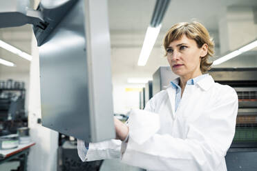 Female scientist operating printing machine in laboratory - JOSEF04346