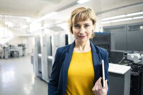 Lächelnder Manager mit digitalem Tablet in der Druckindustrie - JOSEF04357