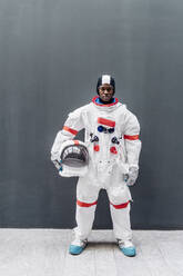 Male astronaut standing in front of gray wall - MEUF02695