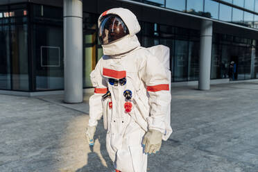 Male astronaut wearing space suit walking on footpath - MEUF02698