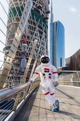 Male astronaut standing on one leg at bridge - MEUF02713