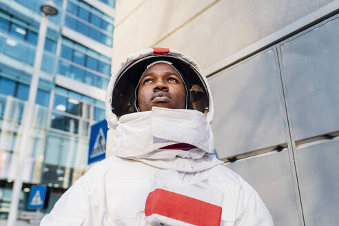 Männlicher Astronaut schaut weg, während er die Stadt erkundet - MEUF02723