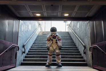 Male astronaut standing in front of staircase - MEUF02726