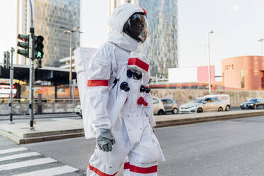 Mittlerer Erwachsener Astronaut beim Überqueren der Straße in der Stadt - MEUF02731