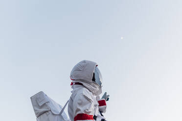 Male astronaut standing while pointing at sky - MEUF02750