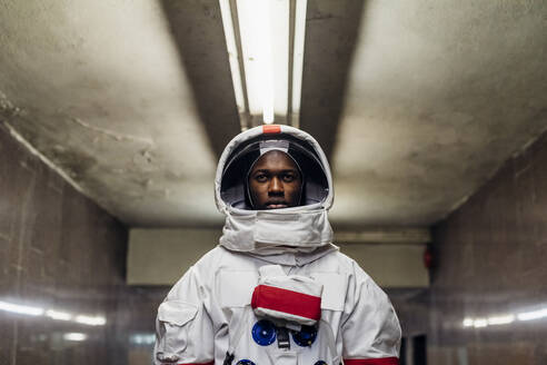 Serious man wearing space suit in basement - MEUF02759