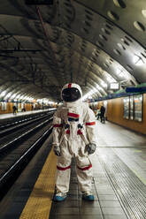 Männlicher Astronaut auf einer Bahnstation stehend - MEUF02761