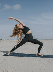 Young woman stretching exercise at beach - OIPF00652