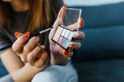 Young woman with brush holding make-up palette - XLGF01739